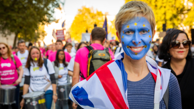 The People's Vote March, London, Blue face, Woman, European flag, Union Jack flag, drummers, March, smile, painted face, ©BronacMcNeill